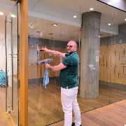 1a Clean NRW - Eine Reinigungskraft in Düsseldorf reinigt gerade eine Glastür. Die Arbeit erfolgt sorgfältig mit einem Abzieher und einem Reinigungstuch. Sauberkeit steht im Vordergrund.