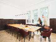ALTE STADTKASSE - Ihr Raum für Workspaces | Meetings | Events - Ein stilvoller Meetingraum in der Alten Stadtkasse Oldenburg, ausgestattet mit einem großen Konferenztisch und eleganten Polsterstühlen. Helle Fensterfronten sorgen für eine angenehme Atmosph