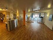 Ambulantes Operationszentrum Eckernförde - Eingangsbereich einer modernen Arztpraxis mit Holzfußboden, Empfangstresen, gläsernen Türen zu Behandlungsräumen