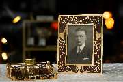 Antiquitäten  | Antikes in Nymphenburg Franz Killer | München - Der kunstvoll gefertigte rechteckige Bilderrahmen besticht durch sein typisches Jugendstil-Design mit floralen Einlegearbeiten in Gold auf dunklem Holzgrund. Im Rahmen befindet sich ein klass