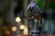 Antiquitäten  | Antikes in Nymphenburg Franz Killer | München - Diese originelle Bronzefigur zeigt einen stilisierten Vogel mit großen Proportionen und ausdrucksstarkem Blick, der auf einem Bein steht. Auf dem anderen Fuß sitzt ein kleiner Frosch, dem der