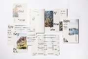Bande für Gestaltung - Corporate Design und die Printkommunikation des Immobilienunternehmens Soy Real Estate. Die verschiedenen Printprodukte sind auf einer hellen Fläche arrangiert und präsentieren eine elegante Typografie kombiniert mit eindrucksvollen