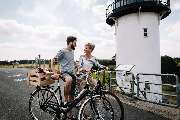 Best Western Hotel Das Donners - Couple standing with their bicycles in front of the ‘Dicke Berta’ lighthouse