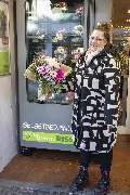 Blumen Risse Blumenladen Dortmund-Mengede - Frau steht mit gekauftem Blumenstrauß aus dem Blumen-Risse Blumenautomat in Dortmund-Mengede