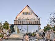 Carolin Dißmann Architektur GmbH | Architektin München - Die Gartenansicht der modernisierten Stadtvilla verbindet historische Substanz mit zeitgemäßer Leichtigkeit. Große Glasflächen, ein filigraner Balkon und fein abgestimmte Grüntöne schaffen eine harm