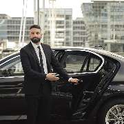 Chauffeurservice München - Onyx - Chauffeur vor der Limousine in Münchens Innenstadt