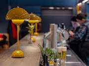 Das Blümchen | Restaurant Friedrichshafen - Bartheke mit gelben Lampen und frischen Kräutern im Restaurant Das Blümchen Friedrichshafen.