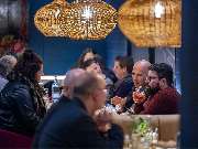 Das Blümchen | Restaurant Friedrichshafen - Gäste genießen Tapas und Drinks im Restaurant Das Blümchen Friedrichshafen unter warmem Licht.