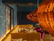 Das Blümchen | Restaurant Friedrichshafen - Gemütlicher Sitzbereich mit gelben Polsterbänken und Rattanlampen im Restaurant Das Blümchen Friedrichshafen – stilvolles Ambiente mit Schwarzwald-Charme.