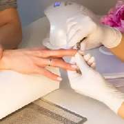 Derma First Cosmetics - Das Bild zeigt eine professionelle Maniküre, bei der die rechte Hand einer Frau gepflegt und kosmetisch behandelt werden. Die Hand liegt stabil auf einer sauberen Unterlage, während eine Fachkraft die Nägel formt, vorbereitet oder 