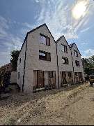 E&E Gebäudereinigung - E&E Gebäudereinigung Moderne Reihenhäuser im Neubauzustand mit hellen Klinkerfassaden, großen Fenstern und sichtbaren Baustellenbereichen, die den Fortschritt der Bauarbeiten und die hochwertige Bauweise hervorheben.