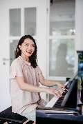 Elite Musik - Elite Musik Eine Frau musiziert am Klavier und vermittelt Freude und Leidenschaft für Musik.