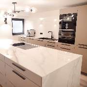 Kochinsel mit einem filigran verarbeiteten Mantel aus Marmor