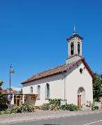 Evangelische Kirche Hahnheim - Evangelische Kirchengemeinde Selzen – Hahnheim – Köngernheim - Die Hahnheimer Kirche besticht durch ihre Klarheit. Altarraum modern gestaltet mit geschwungenem Kreuz und farblichen Akzenten des Künstlers Eberhard Münch.