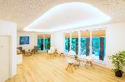 Feelgood-Therapie Praxis für Physiotherapie - Ein großzügiger, modern gestalteter Wartebereich mit großen Fenstern und stilvollen Möbeln.