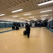 Fein Gebäude-Service - Ein weitläufiger, leerer Raum mit Spiegelwand und Turngeräten wird professionell mit einer Reinigungsmaschine gesäubert.