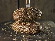Fotografie Viktor Wedel - Fotografie Viktor Wedel Dunkles Körnerbrot mit Sonnenblumenkernen und Kürbiskernen auf rustikalem Holzbrett