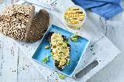 Fotografie Viktor Wedel - Fotografie Viktor Wedel Huhnfreier Salat-Aufstrich auf Brot mit frischem Grün, daneben Brotlaib und Verpackung