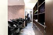Friseur HAARSCHARF natürlich & schön Chemnitz Spezialisten für Extensions und Farbtechniken, Brautstyling - Das Bild zeigt den Waschbereich eines Friseursalons mit einer Reihe von stilvollen, schwarzen Waschbecken, die ergonomisch für eine bequeme Haarwäs