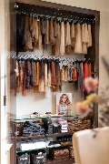 Friseur HAARSCHARF natürlich & schön Chemnitz Spezialisten für Extensions und Farbtechniken, Brautstyling - Das Bild zeigt eine sorgfältig organisierte Schauvitrine für Haarverlängerungen in einem Friseursalon. In der oberen Hälfte des Schranks hängen zah