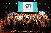 Gastronovi GmbH - Eine große Gruppe von Menschen steht auf einer Bühne vor einer Leinwand mit dem Logo von „gn connect“. Es handelt sich um eine Veranstaltung, bei der eine Gemeinschaft aus der Gastronomie- und Digitalisierungsbranche zusammenkommt, im Ra