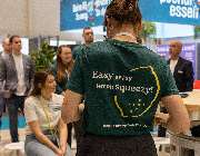 Gastronovi GmbH - Gastronovi-Mitarbeiterin trägt ein T-Shirt mit dem Spruch „Easy peasy lemon squeezy!“ – und kommt damit humorvoll ins Gespräch mit Messebesuchern. Ein sympathischer Auftritt, der zeigt: Digitalisierung darf auch Spaß machen.