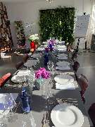 Geschlossene Gesellschaft - Geschlossene Gesellschaft bietet einen hell gedeckten Tisch mit weißen Tellern, Gläsern und Blumenschmuck für ein Social Dining Erlebnis in Hamburg.