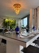 Geschlossene Gesellschaft - Geschlossene Gesellschaft präsentiert einen edel gedeckten Esstisch mit stilvoller Tischdekoration, Gläsern und modernem Ambiente unter einem goldenen Kronleuchter in Hamburg.