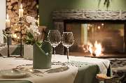 Gourmetrestaurant Silberdistel - In alpinen Farben eingedeckter Tisch neben dem gemütlichen Kaminfeuer.