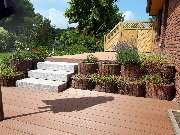 GreenFairway e.K. - Bau einer WPC Terrasse auf verschiedenen Ebenen mit Granitstufenblöcken und Holzsichtschutzelementen von GreenFairway e.K.