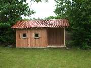 Hubert Bader Holzbau GmbH - Ein ganz besonders schönes Gartenhaus, mit Lärchenfassade und Ziegeleindeckung. Wir bieten Ihnen auch Caports oder Terrassenüberdachungen mit Glasdach an.