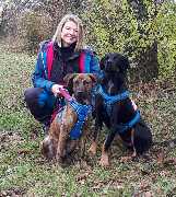 Hundeschule Martin Rütter Göppingen-Heidenheim - Hundeschule Martin Rütter Göppingen-Heidenheim Hundetrainerin Susanne Michels mit zwei Hunden beim Training auf einer Wiese. Gemeinsames Training für Sozialisation, Bindung und Grundgehorsam in der Hundesch