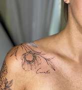 Inklabs Tattoo Studio - Halle - Fineline Tattoo auf der Schulter, das Richtung Dekolleté verläuft. Eine halbgeöffnete Blüte mit Blättern und dazu ein Name.