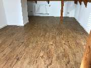 Jörg Schirmer Boden- und Parkettleger - In dieser Dachgeschosswohnung haben wir einen Design-Belag in rustikaler Eichenoptik von Amtico verlegt und anschließend weiße Sockelleisten angebracht.