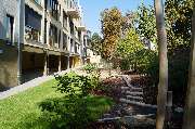 Johanniter-Kita HOCHhinaus - Großzügige Außenfläche hinter dem Haus mit Barfußpfad und überdachtem Spielbereich.