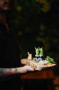 Julia Reisinger Fotografie - Julia Reisinger Fotografie Authentisches Food-Foto mit frischem Sushi und dekorativen Kräutern auf rustikalem Holzbrett.