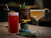 MAUI - Hawasian & Vietnamese Restaurant | München Ludwigpalais - Dreier-Set aus kreativen Cocktails: fruchtiger Longdrink, exotischer Tiki-Drink und eleganter Sour-Cocktail – kunstvoll angerichtet mit Dekoration.