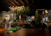 MAUI - Hawasian & Vietnamese Restaurant | München Ludwigpalais - Stilvoll eingerichteter Restaurantbereich mit Holzbalkendecke, Kronleuchtern und üppiger Pflanzen-Dekoration – einladendes Ambiente mit moderner Eleganz.