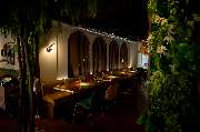 MAUI - Hawasian & Vietnamese Restaurant | München Ludwigpalais - Stimmungsvoll beleuchteter Restaurantbereich mit eleganten Sitznischen, warmem Licht und üppiger grüner Wandgestaltung – ideal für ein stilvolles Dinner.