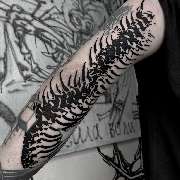 OMEN Tattoo - Berlin Friedrichshain - Abstraktes Blackwork Tattoo am Arm inspiriert von einer verzerrten Wirbelsäule mit dynamischen Linien und Negativraum im modernen künstlerischen Stil.