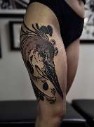 OMEN Tattoo - Berlin Friedrichshain - Blackwork-Tattoo eines abstrakten Reiherkopfes mit floralen Details auf dem Oberschenkel.