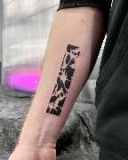 OMEN Tattoo - Berlin Friedrichshain - Rechteckiges Blackwork-Tattoo am Unterarm mit abstraktem Muster aus schwarzen Flächen.