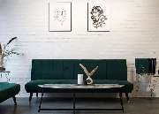 OMEN Tattoo & Piercing - Berlin Mitte - Wartebereich im OMEN Tattoo Studio Berlin Mitte mit Galerie-Flair, heller Einrichtung und freiliegenden, weißen Backsteinwänden sowie Tattoo-Fotos und Trockenpflanzen.