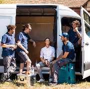 das team der räumungsexperten macht pause und sitzt in einem weißen Sprinter
