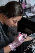 Schmierfink & Robird - Schmierfink & Robird professionelle tätowiererin konzentriert beim stechen eines fine line tattoos, präzise arbeit und saubere hygiene in modernem studio