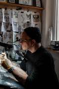 Schmierfink & Robird - Schmierfink & Robird tätowierer im studio mit zahlreichen skizzen, arbeitet konzentriert an tattoo motiv, kreative atmosphäre und präzise handwerkskunst