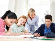 Studienkreis Nachhilfe Memmingen - Nachhilfelehrerin unterstützt ihre Schüler beim Lernen am Tisch.