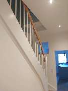 Tischlerei Hennemann - Tischlerei Hennemann harmonisch gestaltete Treppe mit weißem Anstrich und Holzhandlauf. Dokumentiert hochwertigen Innenausbau, Geländermontage und moderne Wohnraumgestaltung.