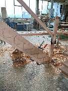 Tischlerei Hennemann - Tischlerei Hennemann im Aufbau befindliche Holztreppe in einer Werkstatt, sichtbar gefräste Aufnahmen und Montagearbeiten, ideal zur Präsentation handwerklicher Präzision im Treppenbau.